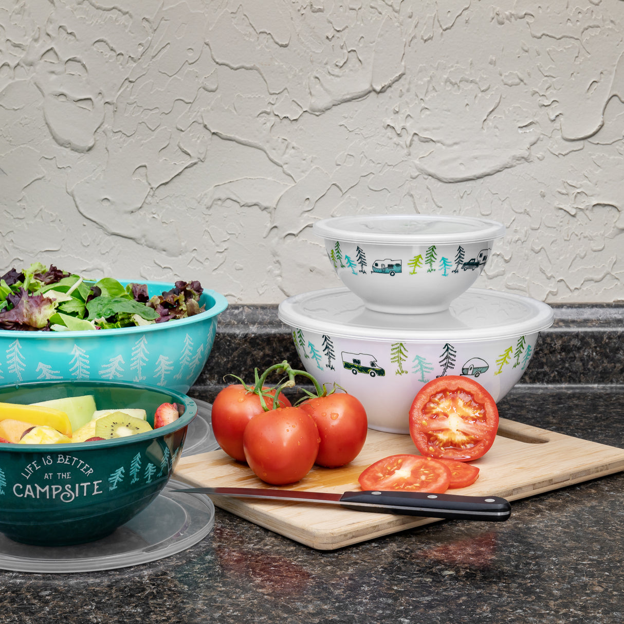 Bowls set up on a table surface with a cutting board and salad