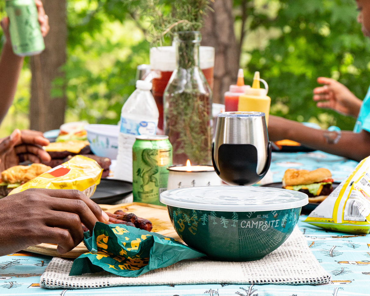 picnic table at a campsite with food and happy family eating on a sunny day