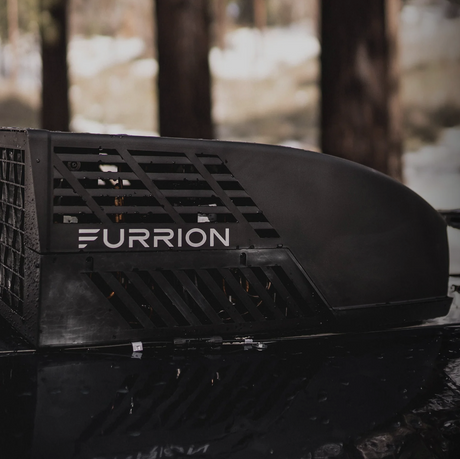 Furrion RV A/C installed on top of RV with wooded background 